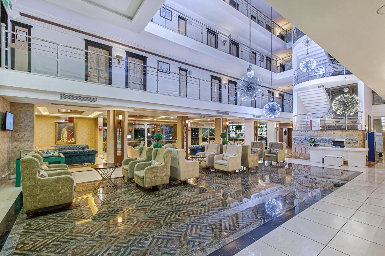 Sealife Family Resort Hotel Antalya Exterior photo The image shows a spacious hotel lobby with a modern and elegant design. The area features a high ceiling with multiple levels, large windows allowing natural light to filter in, and stylish decor elements. There are comfortable seating arrangements 